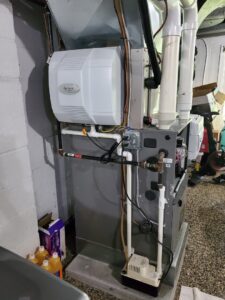 An indoor furnace and air handler unit with an Aprilaire humidifier installed by Bouvy Heating & Air Conditioning Services in Pittsburgh, PA.