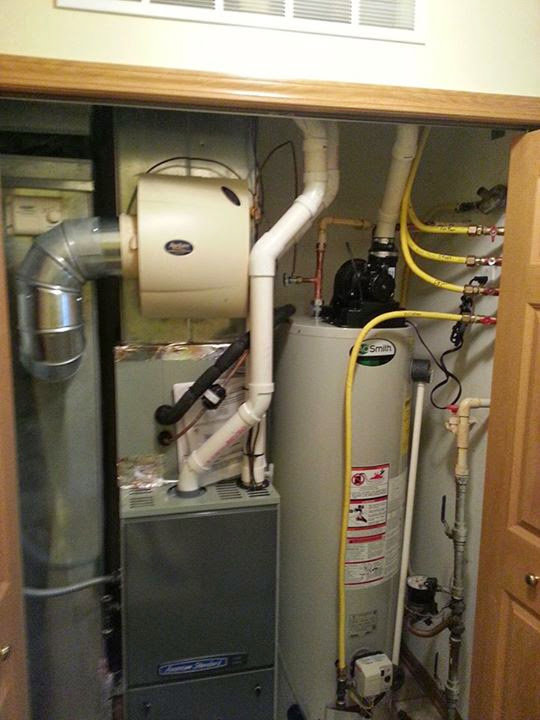 A furnace, humidifier, and water heater system in a utility closet by Complete Comfort Heating & Cooling in Kenosha, WI.