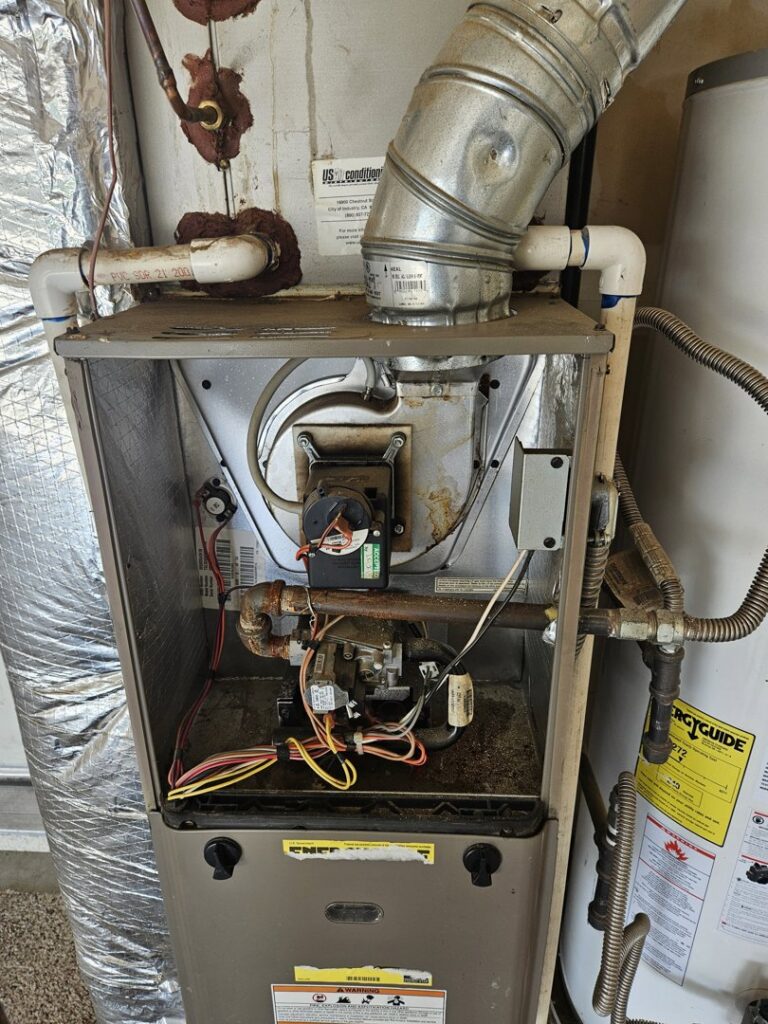 An open furnace unit showing internal components during an inspection by Heritage Heating and Air Conditioning in Nampa, ID