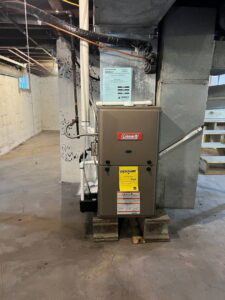 A modern furnace unit installed in a basement by Furnace Doctors Heating & Air Conditioning LLC in Champaign, IL