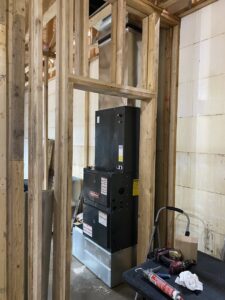 An indoor furnace and air handler unit being installed within a framed wall by Butte Heating & Cooling in Rapid City, SD.