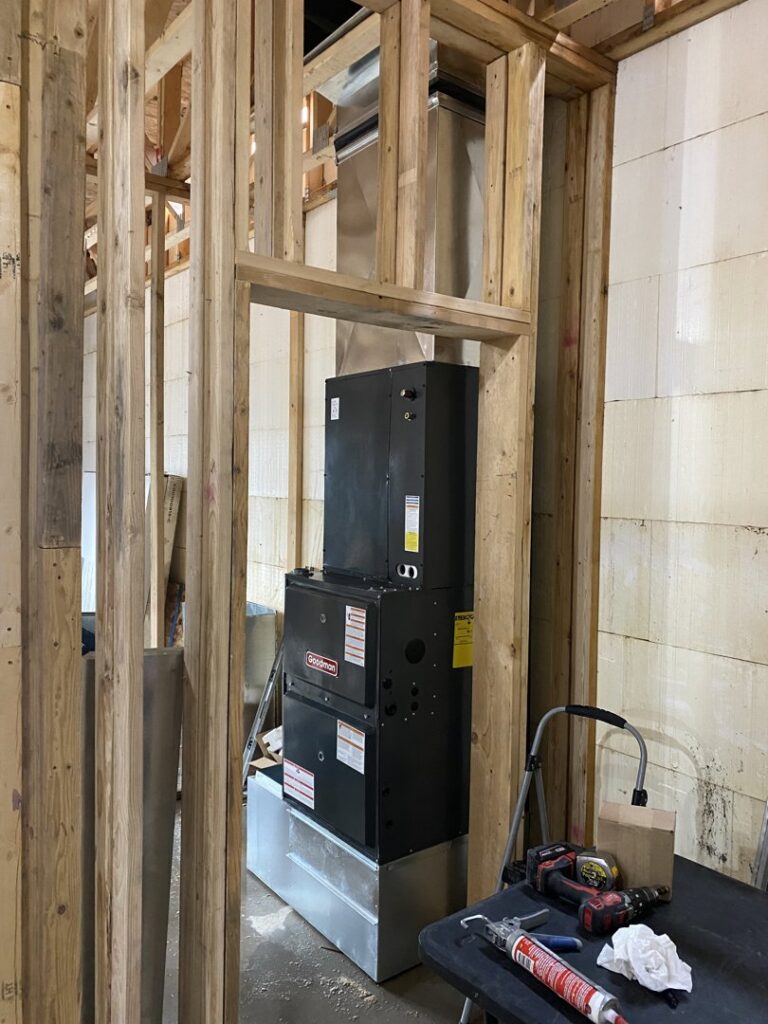 An indoor furnace and air handler unit being installed within a framed wall by Butte Heating & Cooling in Rapid City, SD.
