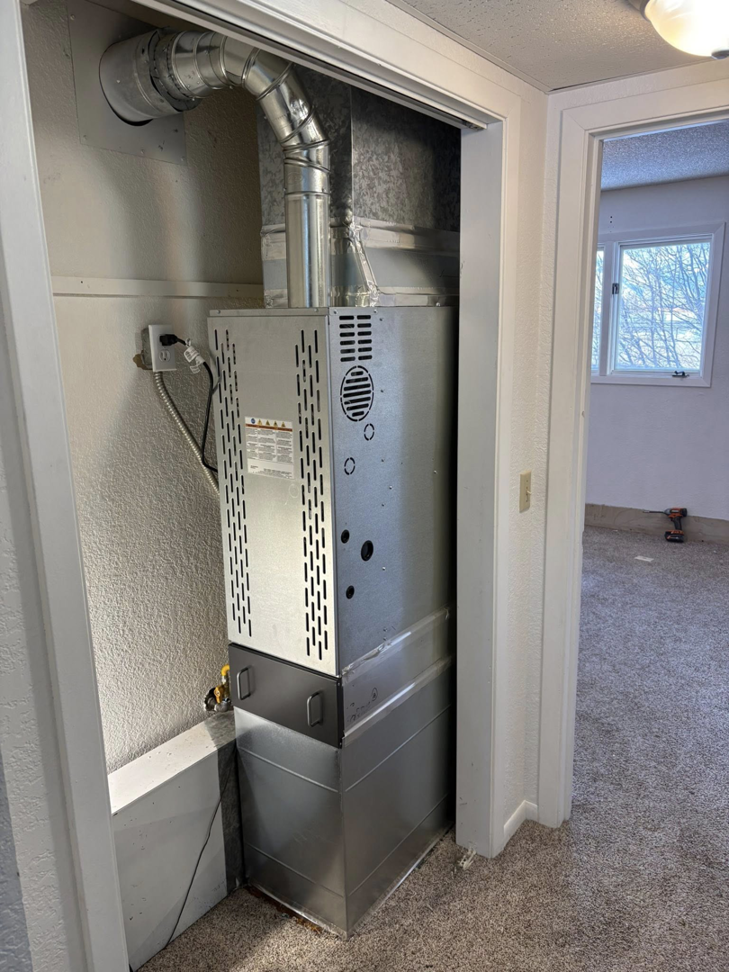 A newly installed furnace and ductwork in a residential closet by Mammoth Heating in Wasilla, AK.