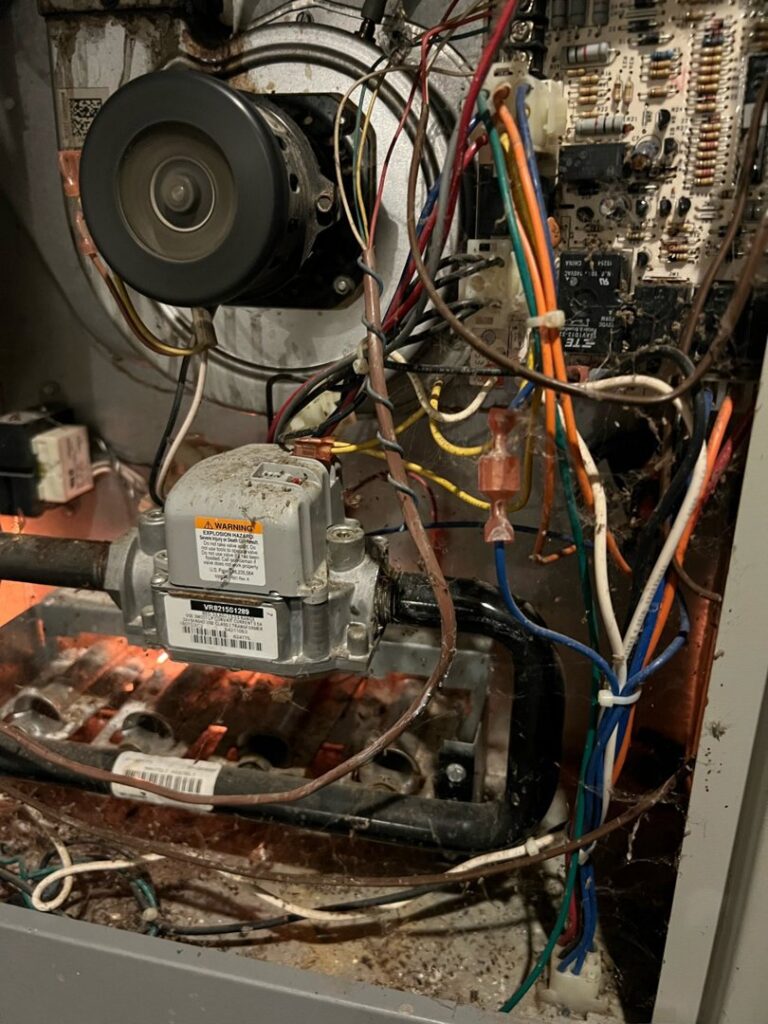 The interior components of a furnace, including wiring and gas valve, serviced by Spartan Mechanical KC in Spring Hill, KS.