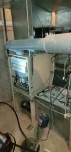 An open furnace unit showing internal components during maintenance or service by Northern Peak Heating & Cooling in Bozeman, MT.