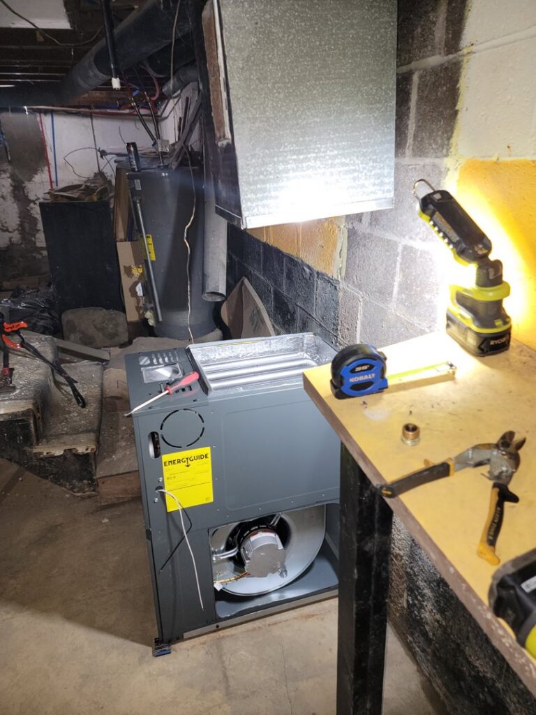 An open furnace unit with tools on a workbench, indicating repair or installation work by Family First Heating and Cooling Repair LLC in Toledo, OH.