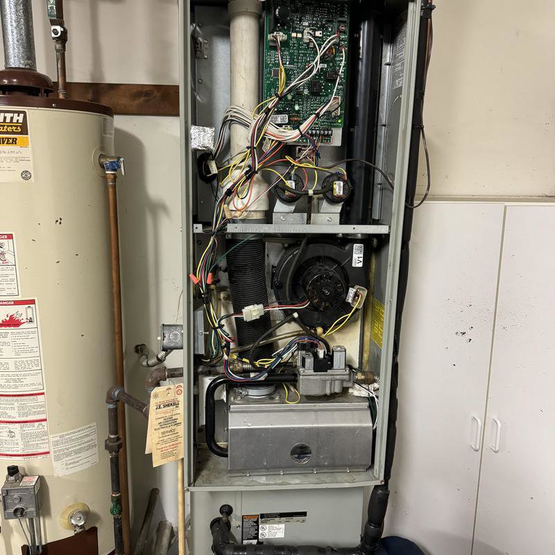 An open furnace unit showing internal components and wiring during a repair by Hodges Heating & Cooling in Owensboro, KY.