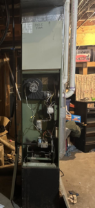 An open furnace unit showing internal components during repair or maintenance by BRY Heat and Air in Elgin, MN