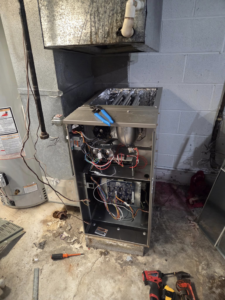 An open furnace showing internal components during repair or maintenance by Orchard Heating-Cooling and Sheet Metal in Stow, OH.