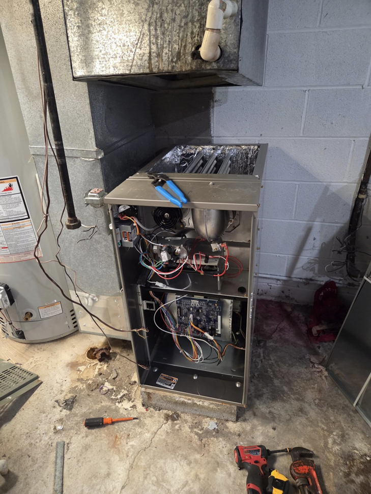 An open furnace showing internal components during repair or maintenance by Orchard Heating-Cooling and Sheet Metal in Stow, OH.