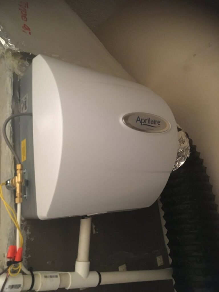 A furnace with its cover removed, showing internal components during a repair or service by Riccardi Heating and Air in Toms River, NJ.