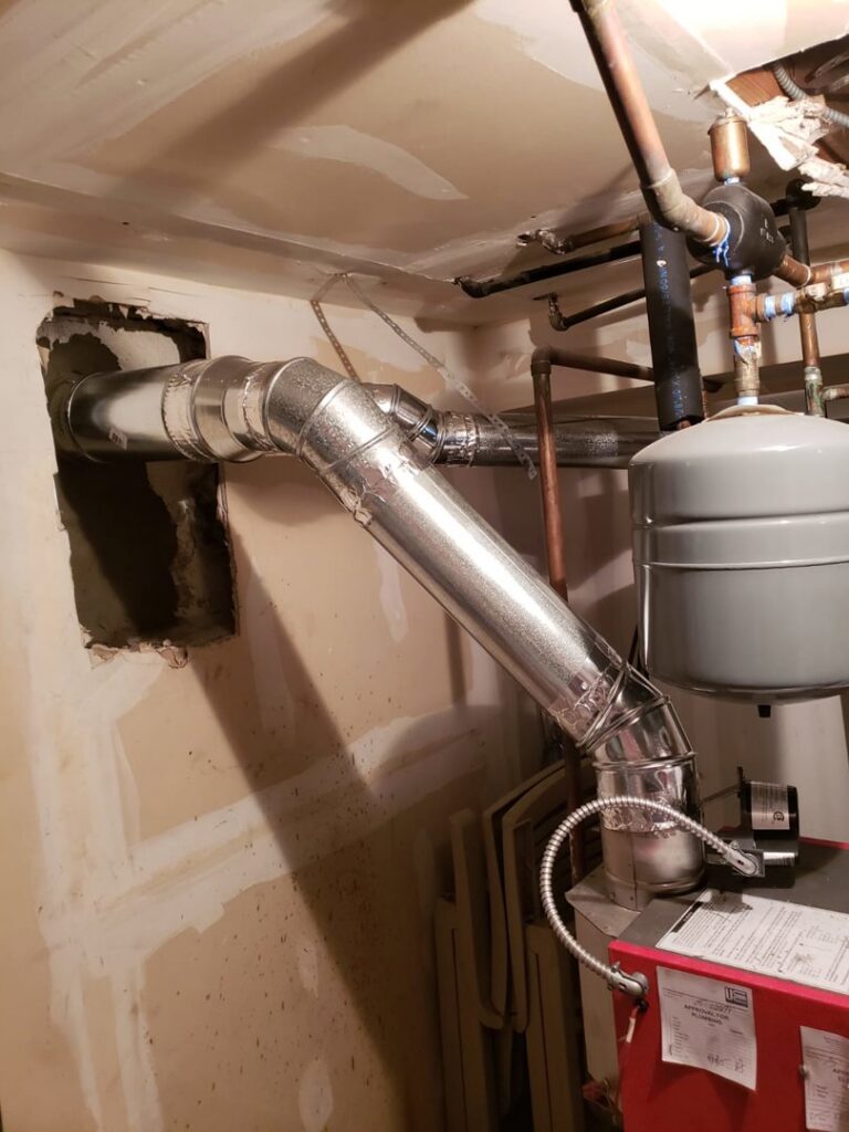 Newly installed metal ductwork for furnace venting in a basement, a service provided by Colombus Chimney in Elizabeth, NJ.