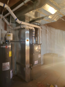 A newly installed furnace, water heater, and extensive HVAC ductwork in a utility room by All Seasons Heating & Cooling Inc in Idaho Falls, ID.