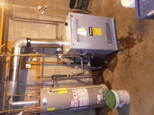 A new furnace and water heater installed in a basement, demonstrating heating and plumbing services by Jones Heating and Refrigeration in Dickinson, ND.