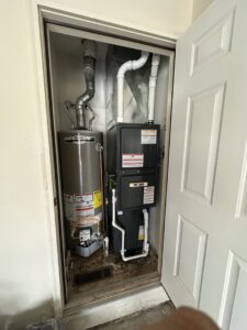 A new furnace and water heater installed in a utility closet by One Hour Heating & Air Conditioning of Springfield in Springfield, MO.