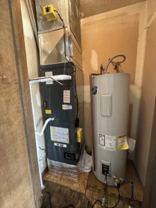 A furnace and water heater installed in a utility closet by One Hour Heating & Air Conditioning of Springfield in Springfield, MO.
