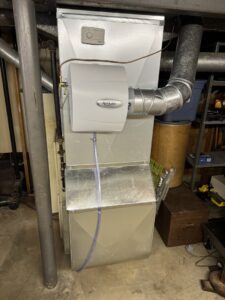 A furnace unit with an Aprilaire humidifier installed, connected to ductwork by Lopez Mechanical HVAC in Kansas City, MO.