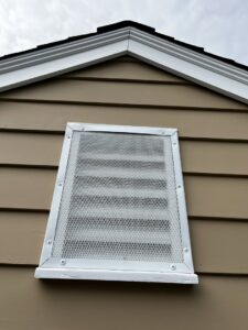 A metal mesh screen installed over a gable vent to prevent wildlife entry by Defense Pest and Wildlife Control in Hartford, CT.
