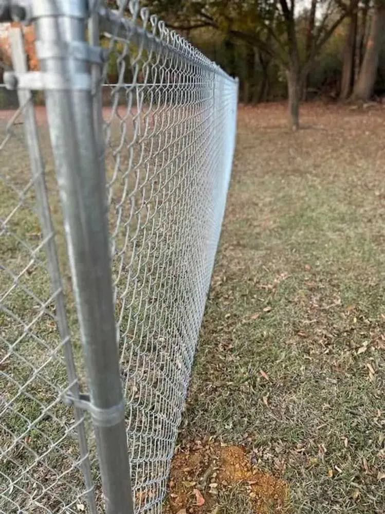 A close-up view of a newly installed galvanized chain-link fence by FenceMax in Spartanburg, SC