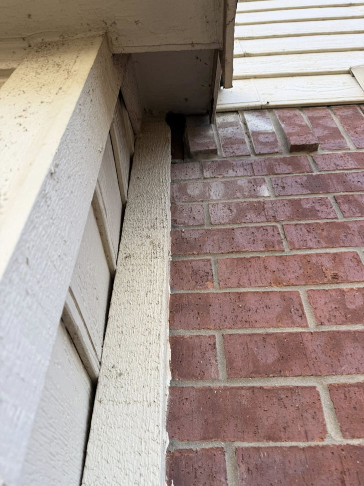 A visible gap between a brick wall and siding, a common entry point for pests and wildlife, inspected by AllGone Services in Euless, TX.