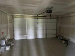 An interior view of a white garage door and opener installation by Phelps Dock and Door in Cave City, KY.