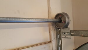 A close-up of a garage door cable drum and shaft, showing components serviced by Az Garage Door in Phoenix, AZ.