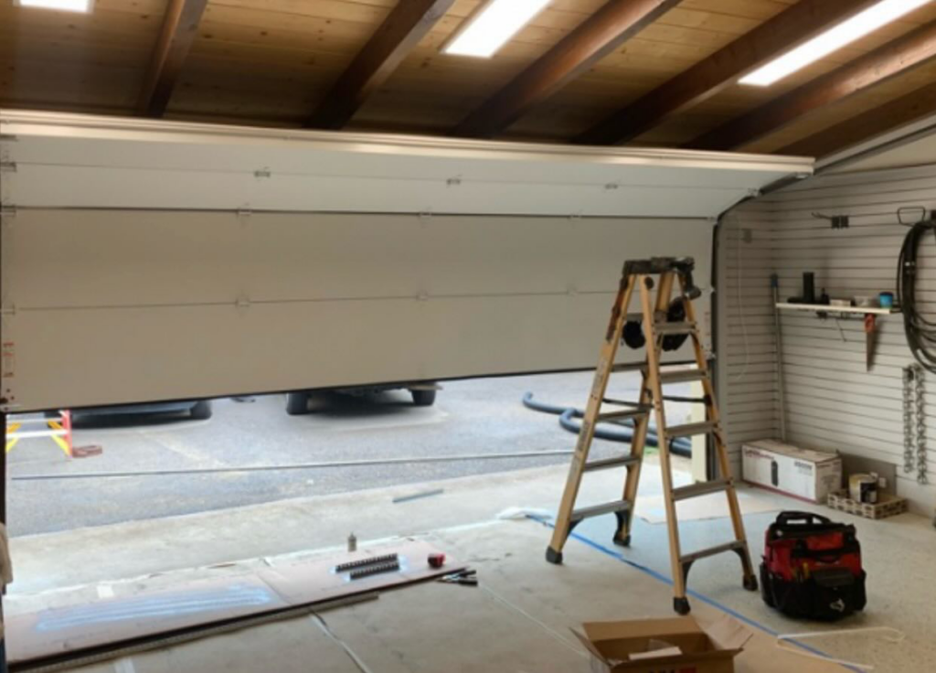 A garage door installation in progress with a ladder and tools on site by Best Garage Door Repair New Orleans LLC in New Orleans, LA.
