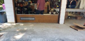 A brown garage door with a window panel being installed by Coast To Coast Garage Door LLC in Vancouver, WA.