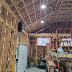 Interior view of a garage door installation in progress, showing tracks and opener in a framed garage by Southcoast Overhead Door & Services in Fall River, MA.