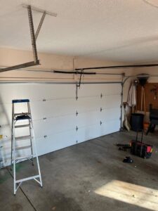 Garage door installation in progress with a ladder and tools by Lenny's Garage Door in Louisville, KY.
