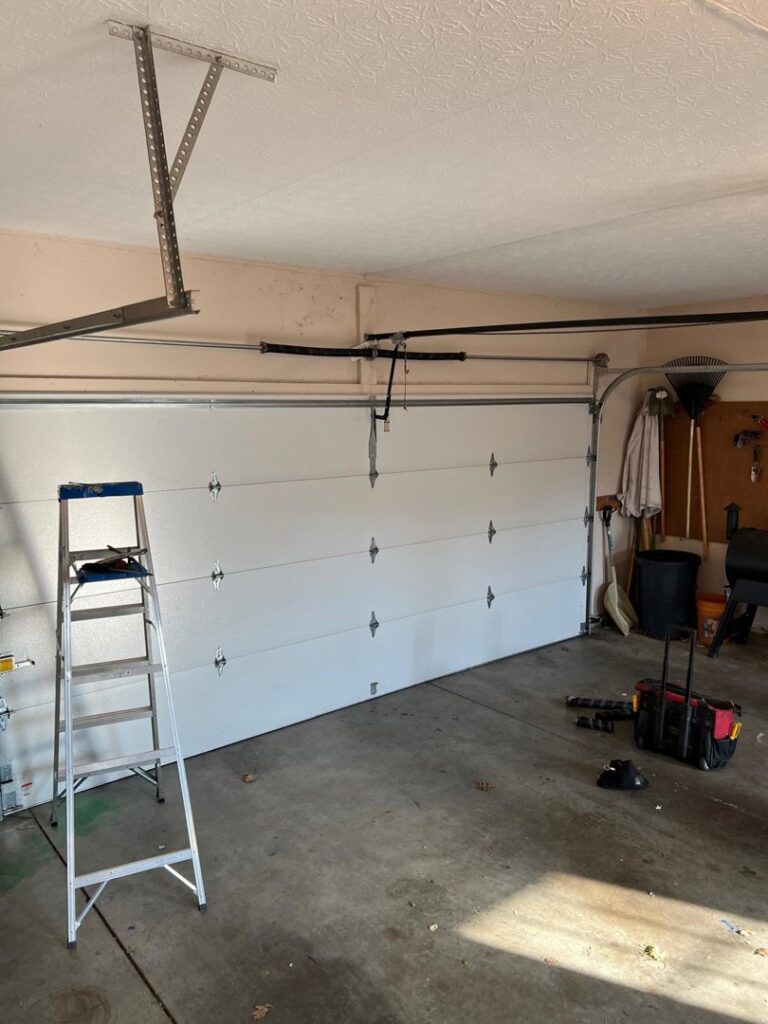 Garage door installation in progress with a ladder and tools by Lenny's Garage Door in Louisville, KY.