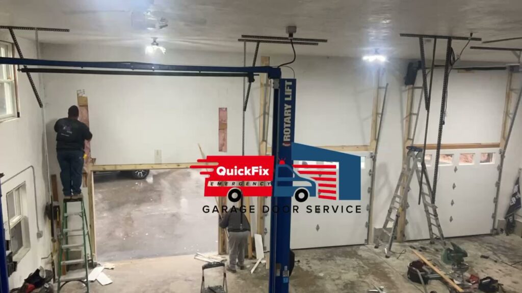 Garage door technicians installing new garage doors in a multi-bay garage for QuickFix Garage Door Service in Brighton, MA.
