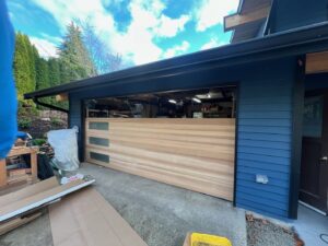A garage door installation in progress, with tools and materials on site by Rainier Garage Door in Bellevue, WA.