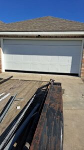 A white garage door installation in progress with parts on a trailer by Residential WorX LLC in Westlake, LA.