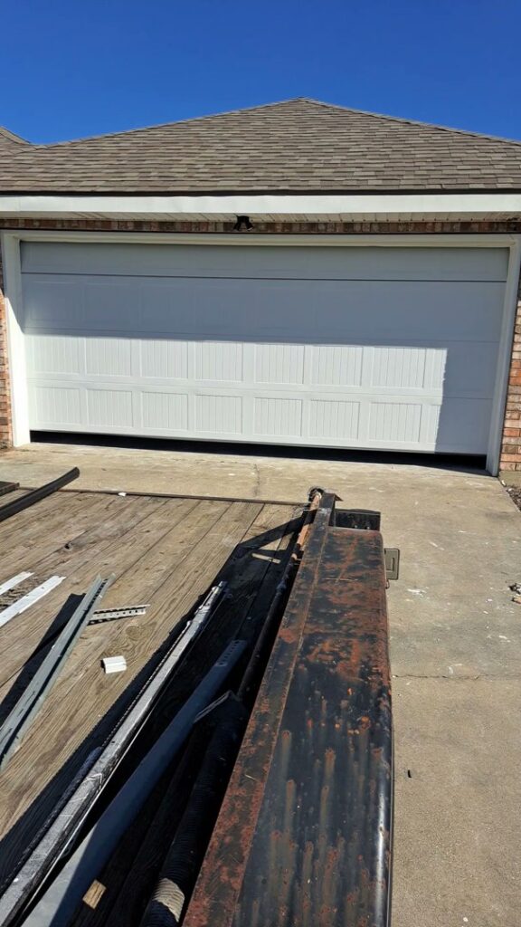 A white garage door installation in progress with parts on a trailer by Residential WorX LLC in Westlake, LA.