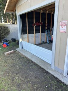 A garage door installation in progress, showing the bottom panel being fitted by Steadfast Garage Door Services LLC in Federal Way, WA.