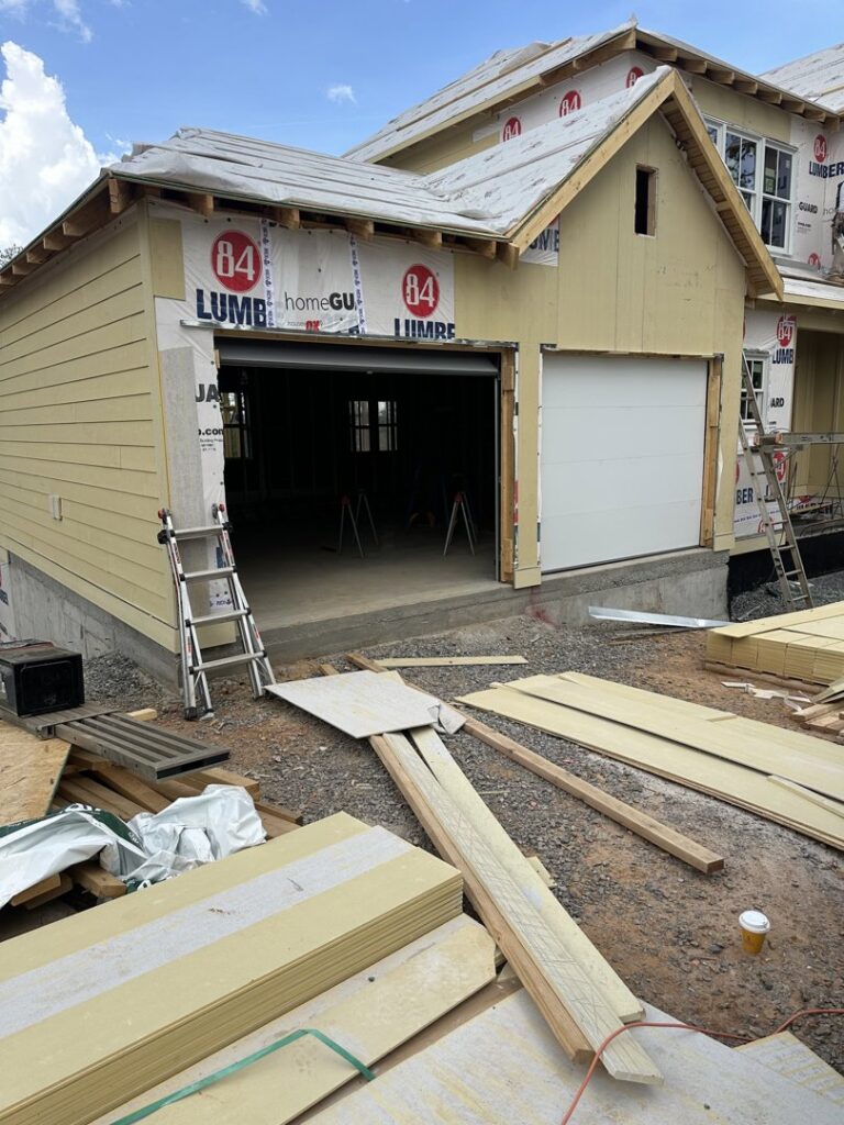 Garage door installation in progress on a house under construction by Platinum Garage Door Services in Helena, AL