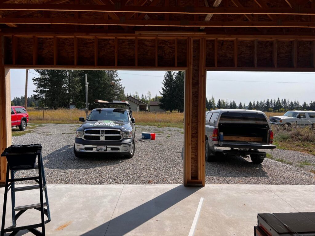 Interior view of a garage at a job site, looking out at a Garage Gecko truck in a rural setting in Spokane, WA.