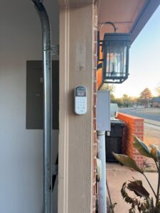 A garage door keypad installed on the exterior wall by 405 Garage Pros in Edmond, OK.
