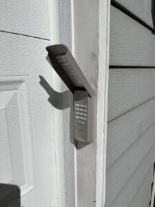 A close-up of a garage door keypad installed on a residential door frame by SCI Door in Yakima, WA