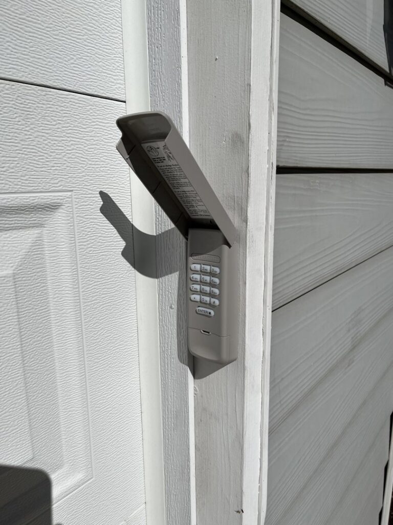 A close-up of a garage door keypad installed on a residential door frame by SCI Door in Yakima, WA