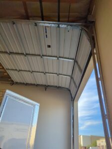 View of a garage door mechanism and chain drive during installation or service by Iconic Garage Door Service in Queen Creek, AZ.