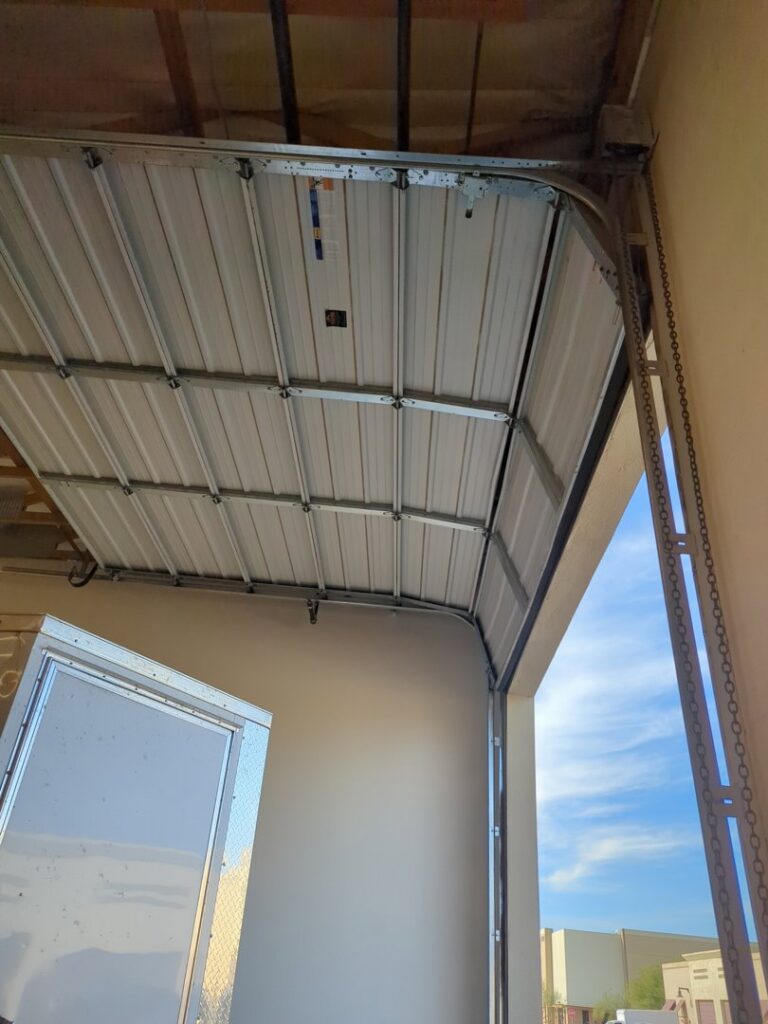 View of a garage door mechanism and chain drive during installation or service by Iconic Garage Door Service in Queen Creek, AZ.