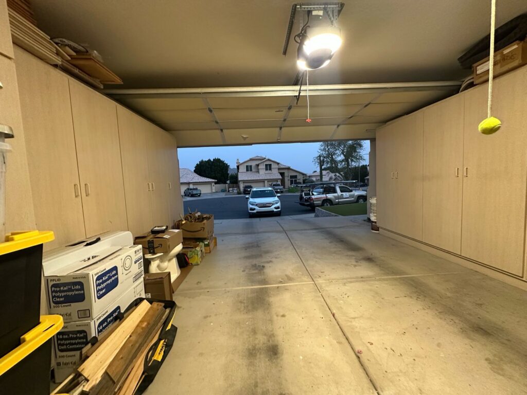 Interior view of an open garage door with a Central Garage Door Repair LLC service truck parked outside in Glendale, AZ.