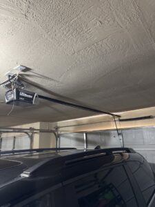 A garage door opener and track system viewed from below, installed by 405 Garage Pros in Edmond, OK.