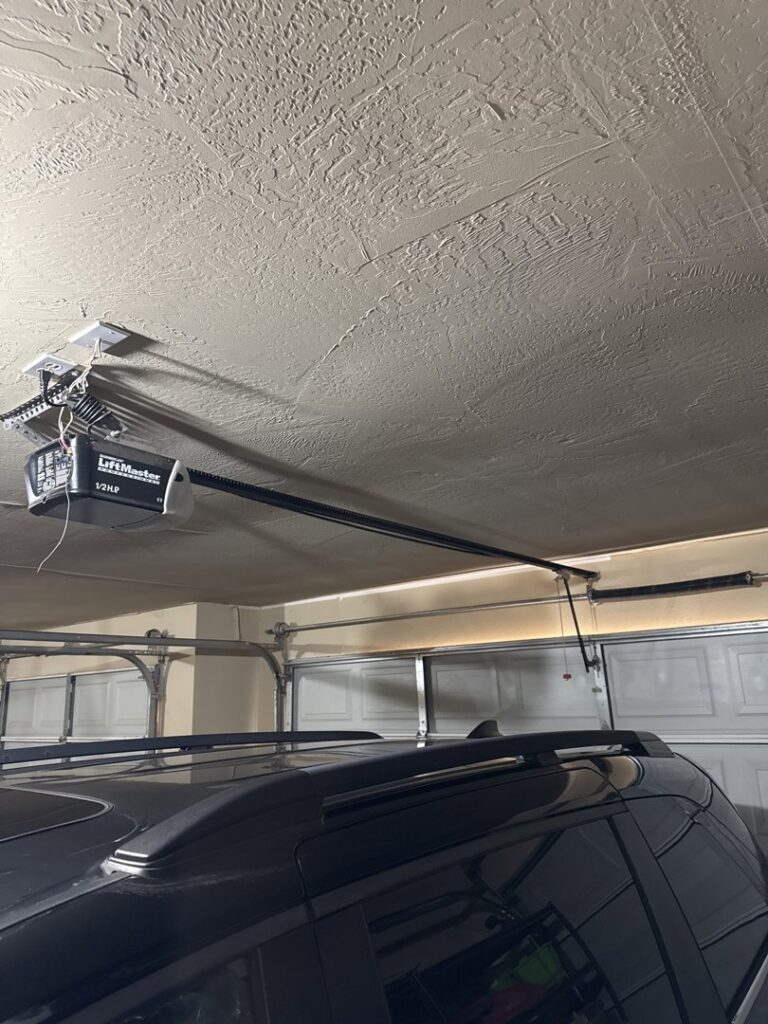 A garage door opener and track system viewed from below, installed by 405 Garage Pros in Edmond, OK.