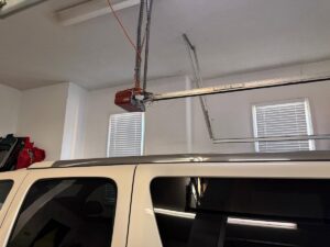 An installed garage door opener and tracks inside a garage, showcasing work by Baystate Garage Door in Milton, MA.