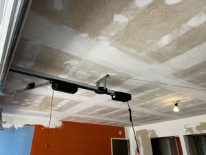 A garage door opener system professionally installed on the ceiling of a garage by Rhino Garage Doors LLC OKC in Edmond, OK.