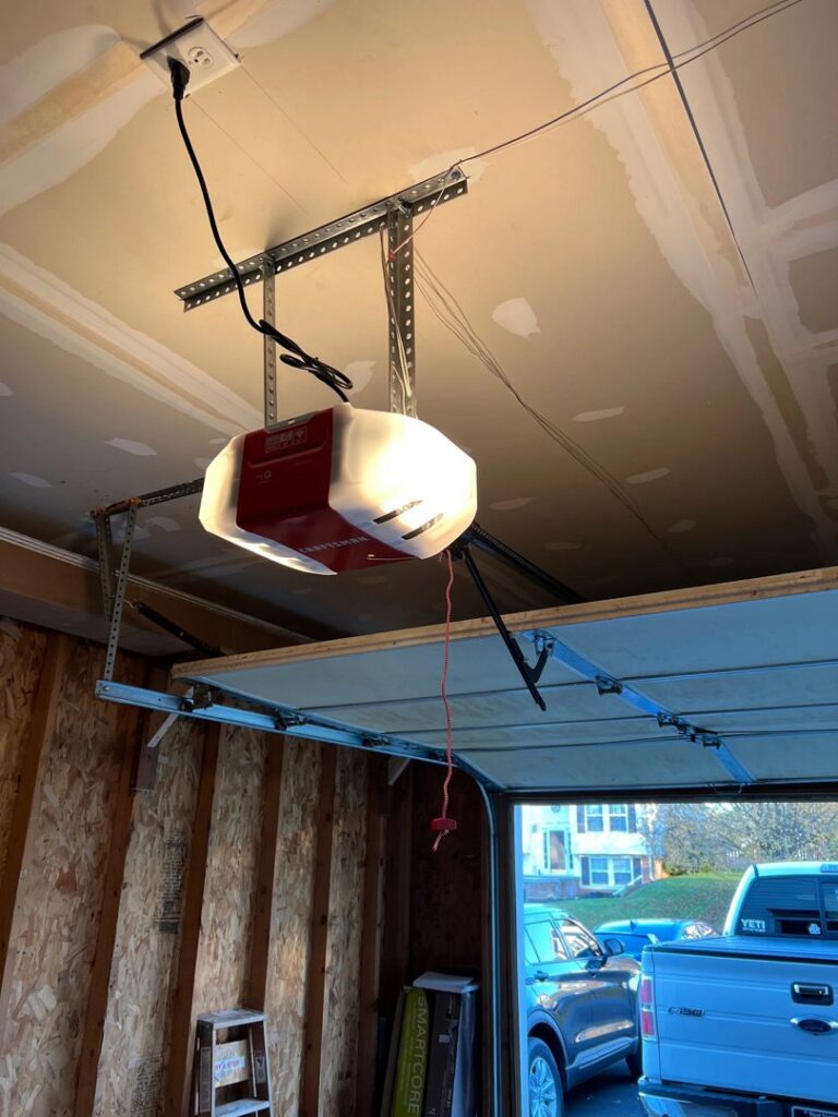 A newly installed garage door opener on the ceiling with the garage door partially open by Door Serv Pro in Inwood, WV.