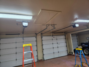 Interior view of a garage showing new garage door openers and ladders during installation by Legacy Garage Doors & Repairs in Church Point, LA.